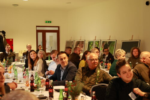 Fotografia účastníkov seminára a v pozadí veľkoformátové fotografie.