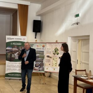 pán prezentuje a v pozadí baner