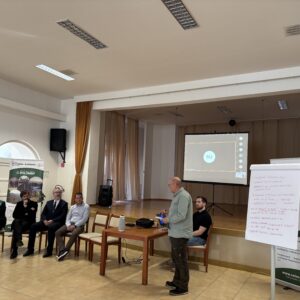 sediacich osôb a jedna v stoji, ktorá prezentuje